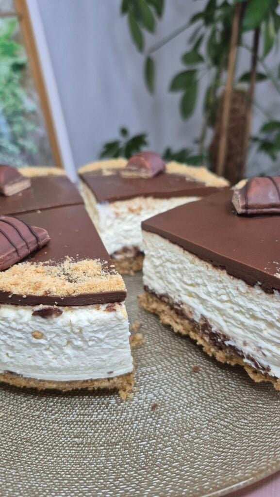 Close-up of a sliced Nutella Kinder Bueno cake with crunchy digestive base, thick mascarpone cream layer, and smooth Nutella top