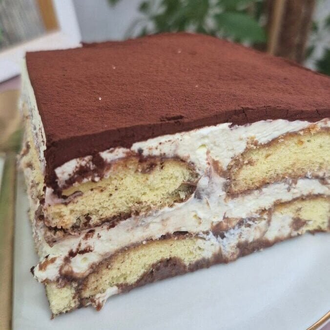 Close-up slice of hot chocolate tiramisu with ladyfinger layers and mascarpone cream