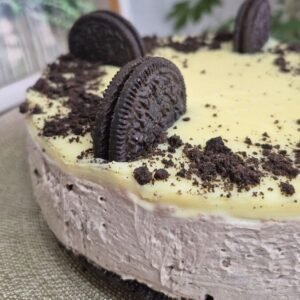 No-bake Oreo cake with mascarpone filling and white chocolate ganache, topped with Oreo crumbs and whole Oreo cookies.