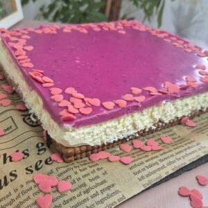 Whole Valentine’s no-bake Nutella biscuit cake topped with pink white chocolate ganache in a square pan.