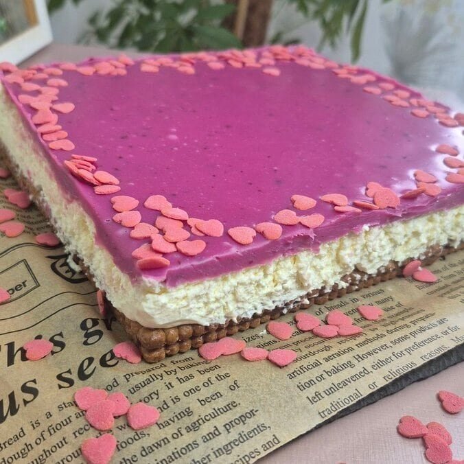 Whole Valentine’s no-bake Nutella biscuit cake topped with pink white chocolate ganache in a square pan.