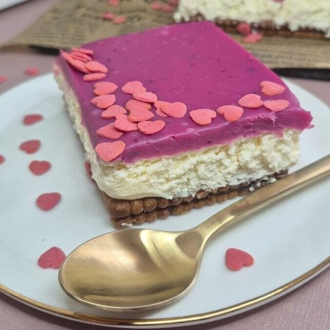 Slice of Valentine’s no-bake Nutella biscuit cake with mascarpone cream and pink white chocolate ganache on a plate.