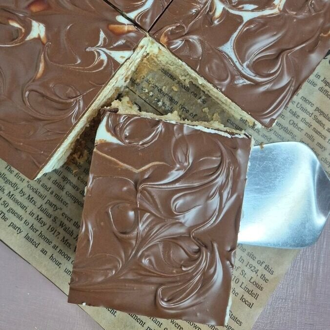 Top view of no-bake petit beurre biscuit cake with mascarpone cream and Nutella topping in a baking dish.