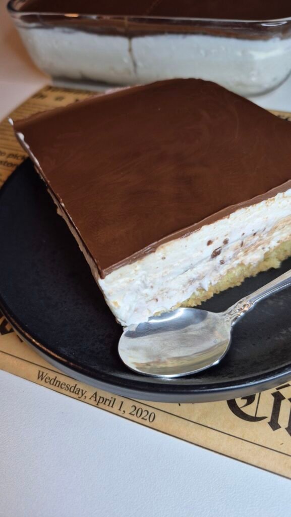 Slice of no-bake Nutella cake with mascarpone cream filling and coffee-soaked ladyfingers on a plate