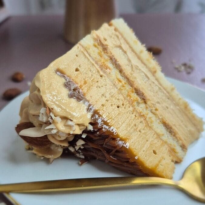 Baked cake slice with dulce de leche and mascarpone cream on a plate.