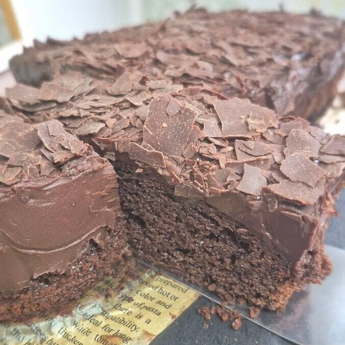 Moist chocolate cake with chocolate topping, sliced to show the soft inside