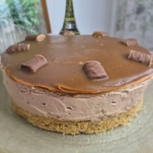 Whole Twix caramel cheesecake with a biscuit crust, creamy mascarpone filling, and glossy caramel topping
