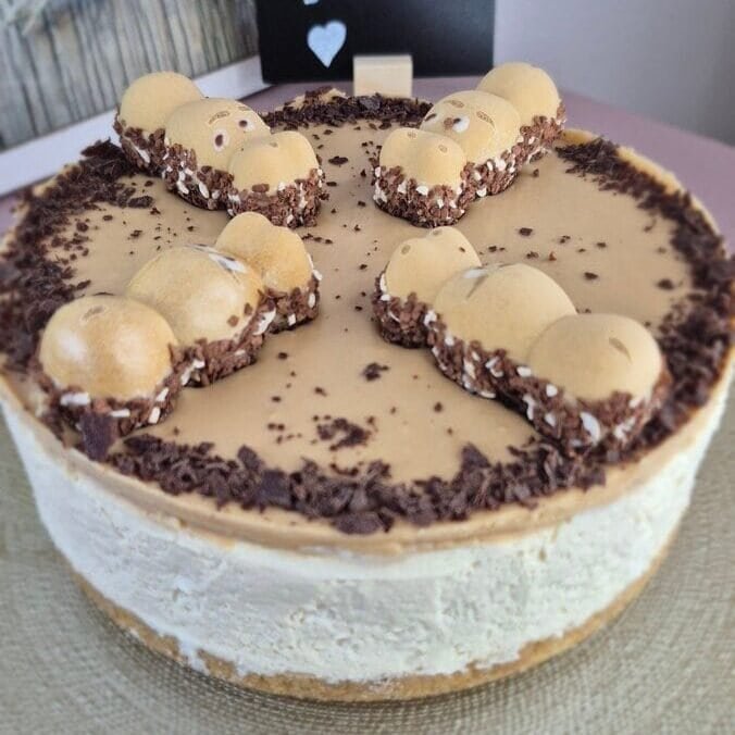 Whole Happy Hippo cheesecake with biscuit base, mascarpone filling, hazelnut topping, and Happy Hippo chocolate pieces