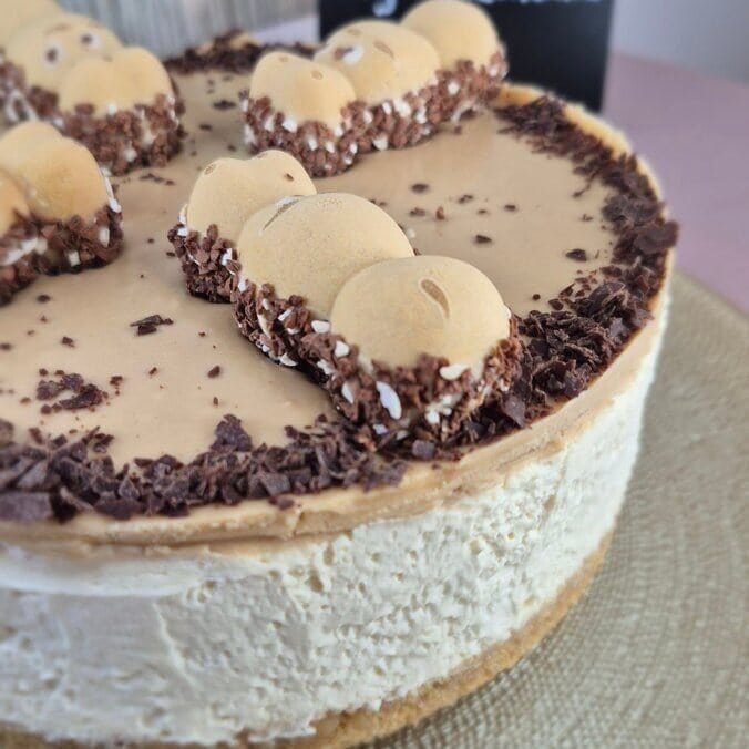 Happy Hippo cheesecake with a biscuit base, creamy mascarpone filling, hazelnut topping, and Happy Hippo pieces on top