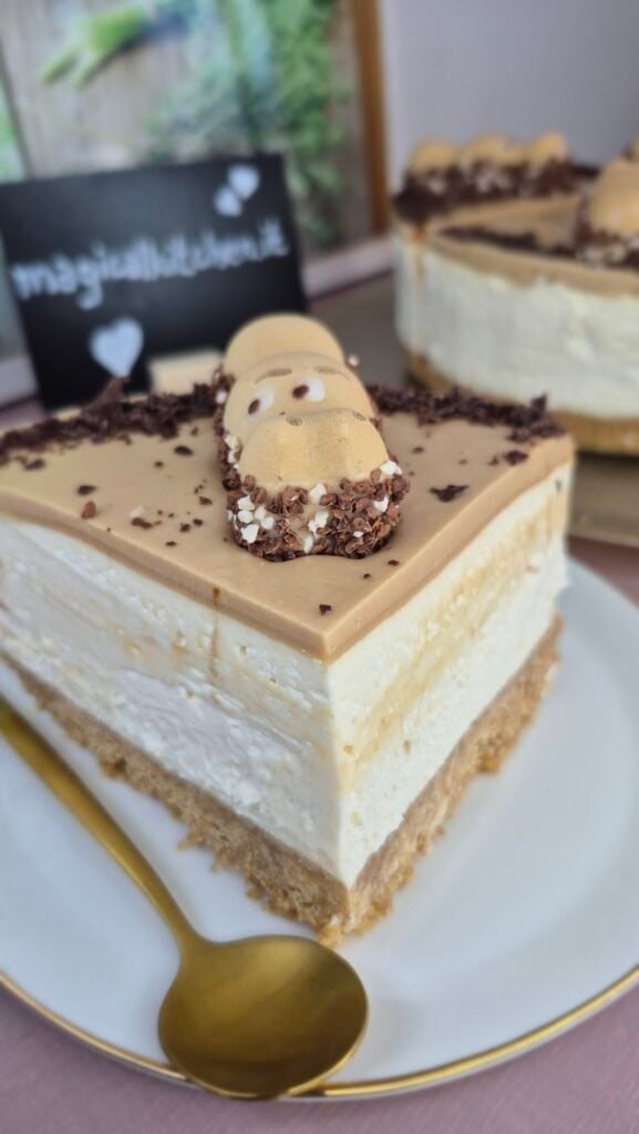 Slice of Happy Hippo cheesecake on a plate with biscuit base, mascarpone filling, hazelnut topping, and a Happy Hippo chocolate piece