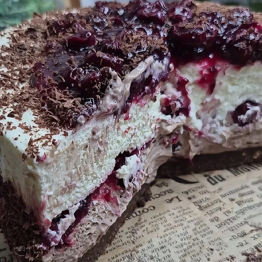 Slice of no-bake Black Forest cake showing mascarpone filling, cherry layers, and chocolate coating