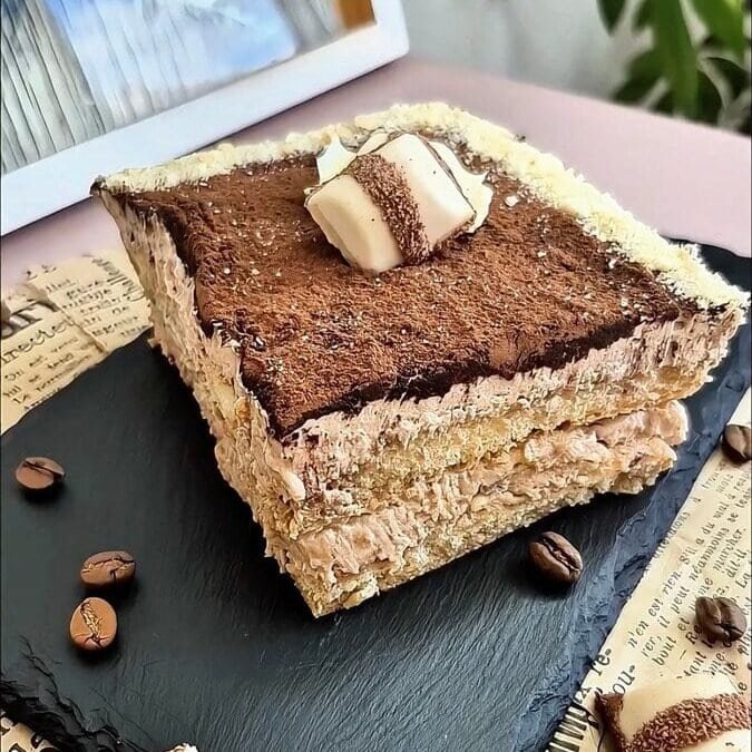 Kinder Bueno tiramisu topped with cocoa powder and a piece of Kinder Bueno