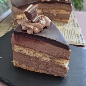 Slice of baked Nutella sponge cake with mascarpone filling and chocolate ganache