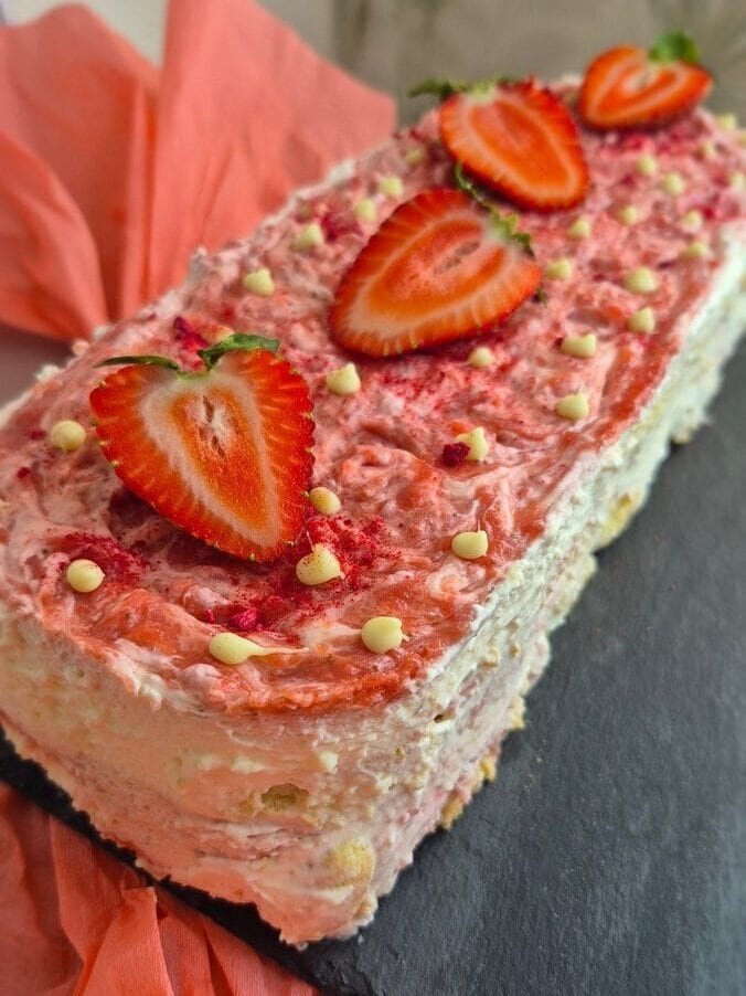 Strawberry tiramisu cake with creamy mascarpone layers, ladyfingers, and fresh strawberries on top