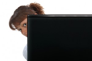 Shy freelance writer peers around computer