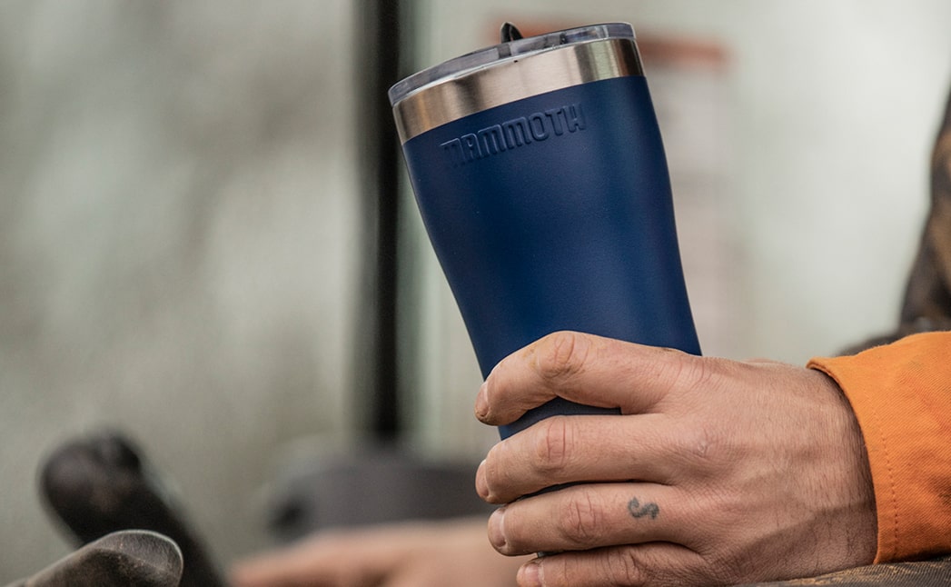 Slide-3---20oz-Rover-min person holding blue 20 ounce rover tumbler