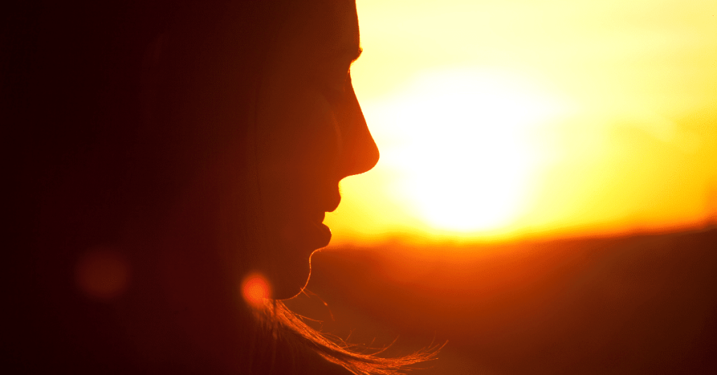 sillouette of young woman with bright sunset in the background