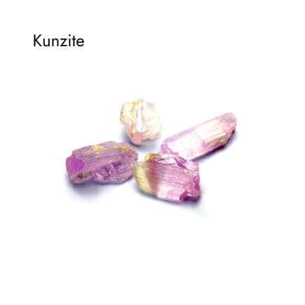 four purple, yellow and white kunzite stones on white background