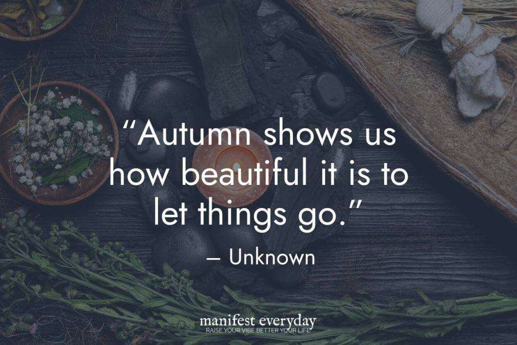 autumn self-care scene with candle, stones and fresh herbs with quote text that reads autumn shows us how beautiful it is to let things go. - unknown manifesteveryday.com