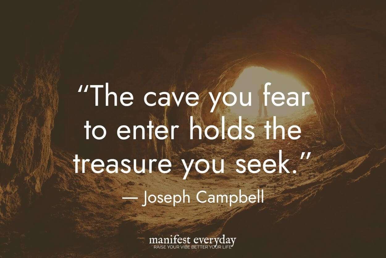 inside a dark cave showing bright lit entrance with person standing in it with quote text that reads 'The cave you fear to enter holds the treasure you seek.' - Joseph Campbell manifesteveryday.com