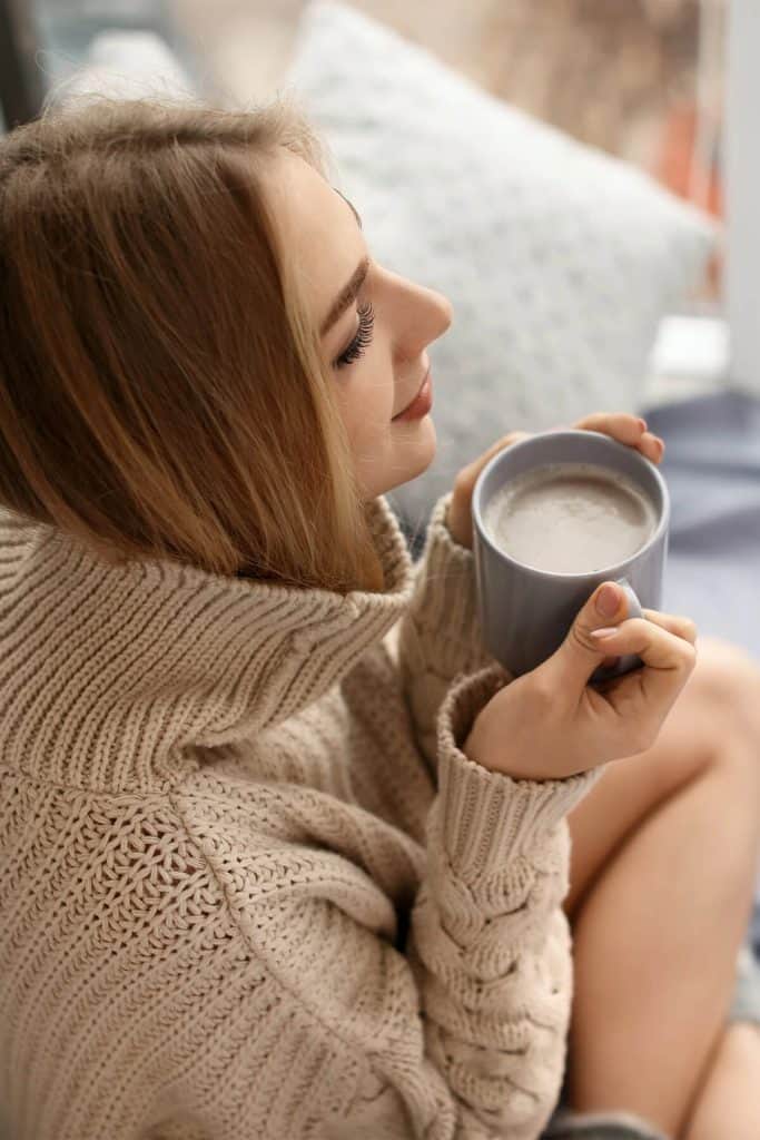 young brunette woman holding a mug of coffee