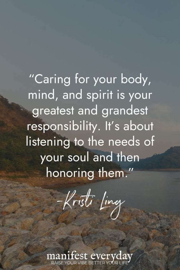 Serene lakeside view with rocky shoreline and mountains, featuring a holistic self-care quote by Kristi Ling about caring for your body, mind, and spirit as your greatest responsibility and honoring the needs of your soul. A meaningful reminder for comprehensive self-care. manifesteveryday.com