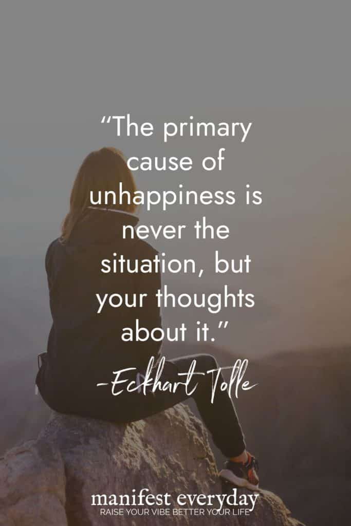 Woman sitting on rock overlooking misty landscape with quote by Eckhart Tolle: "The primary cause of unhappiness is never the situation, but your thoughts about it." manifesteveryday.com