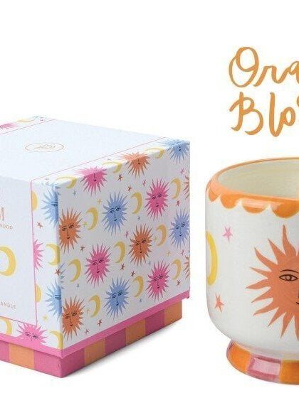 Vela aromática con diseño de sol y luna en tonos naranjas y amarillos, ideal para decorar y crear am.