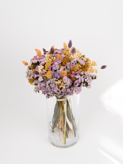 Ramo de flores secas en jarrón de cristal, ideal para decoración y regalos florales.