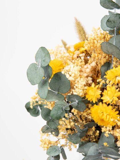 Ramo de flores amarillas y verdes con eucalipto y flores silvestres, ideal para decoración y eventos.