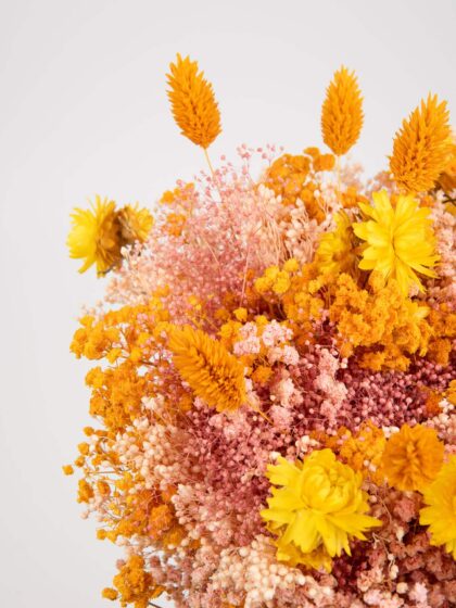 Ramo de flores amarillas y naranjas con variedad de especies y texturas.
