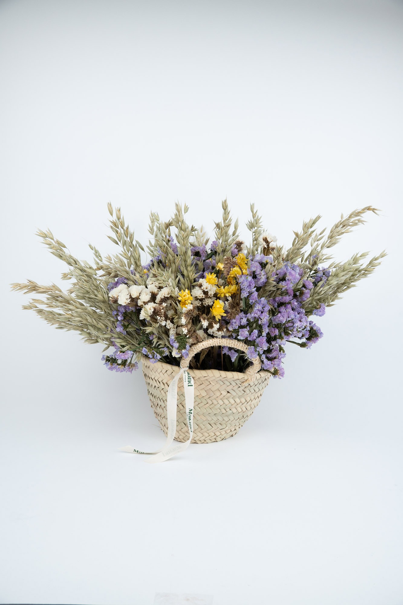Flores secas y lavanda en cesta decorativa para arreglos florales naturales.
