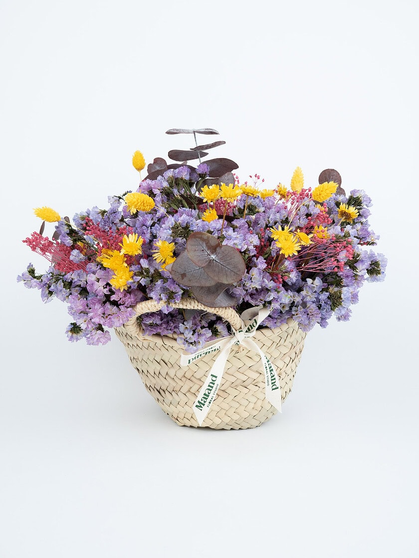 Flores de colores en cesta de mimbre con mariposas decorativas y lazo, ideal para regalos y decoraci.