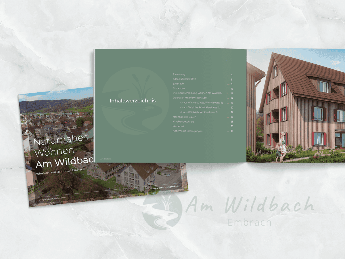 Real estate brochure with text and images showcasing housing development near a natural area, placed on a marble texture background.