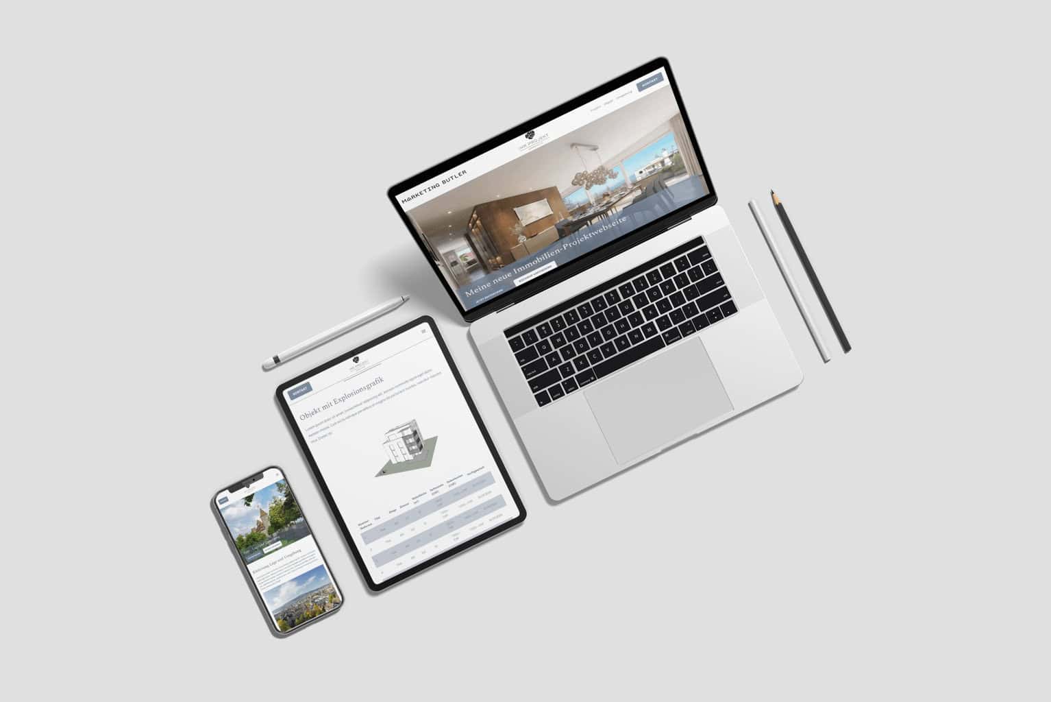 Auf einer hellen Oberfläche sind ein Laptop, ein Tablet und ein Smartphone mit einer Immobilien-Website angeordnet. Daneben liegen zwei Bleistifte und ein Stift, die bei kreativen Unternehmungen hilfreich sein können.