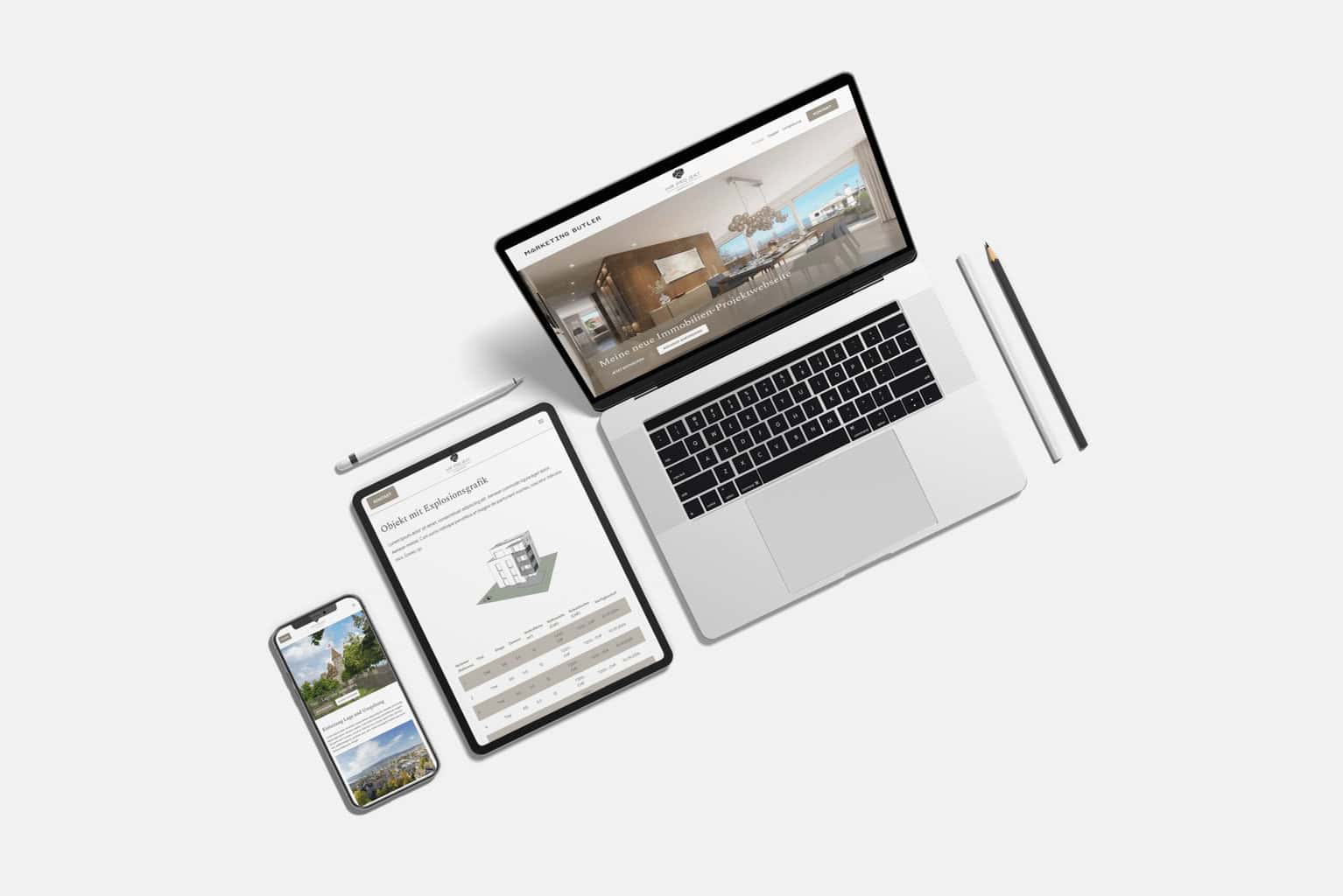 Ein Laptop, ein Tablet und ein Smartphone mit der Immobilien-Website sind auf einer weißen Oberfläche angeordnet. Daneben liegen zwei Bleistifte und ein Stift.