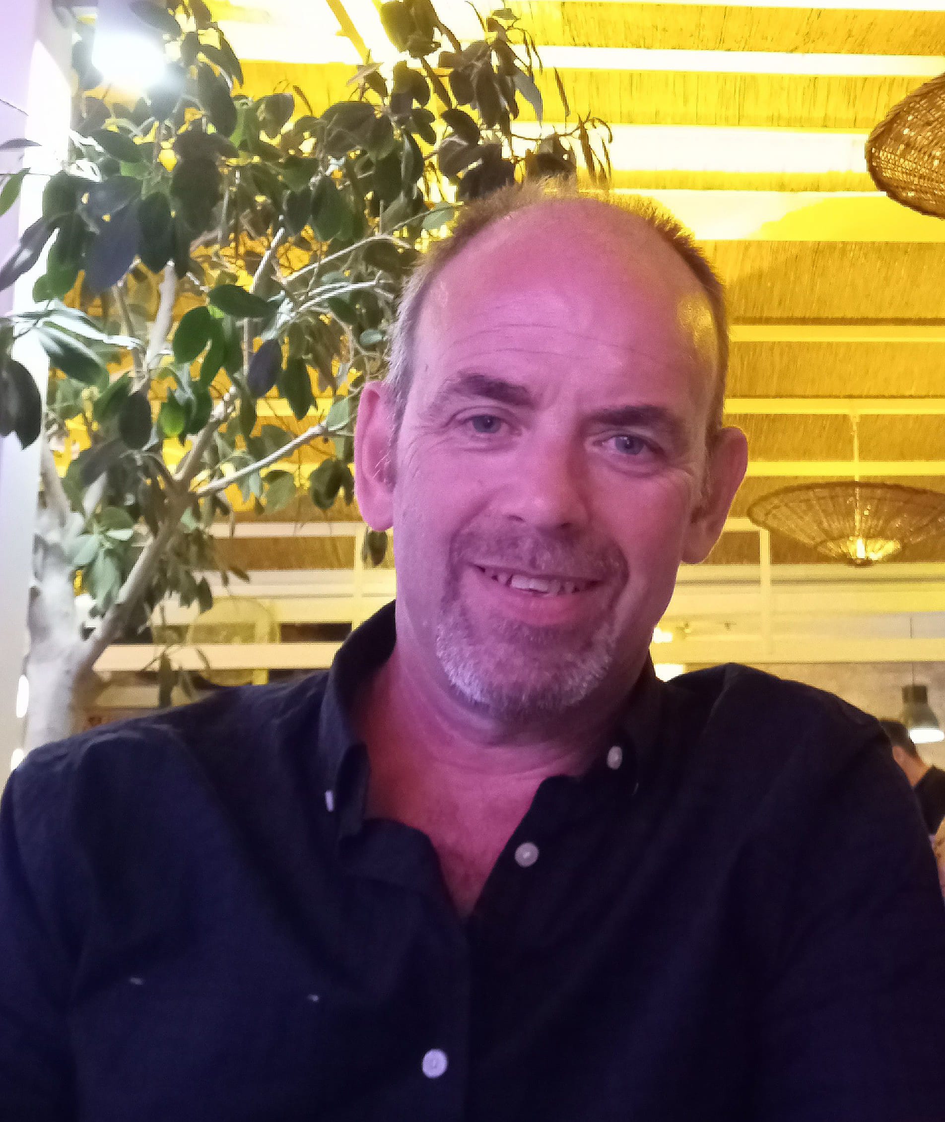Man smiling in a restaurant setting.