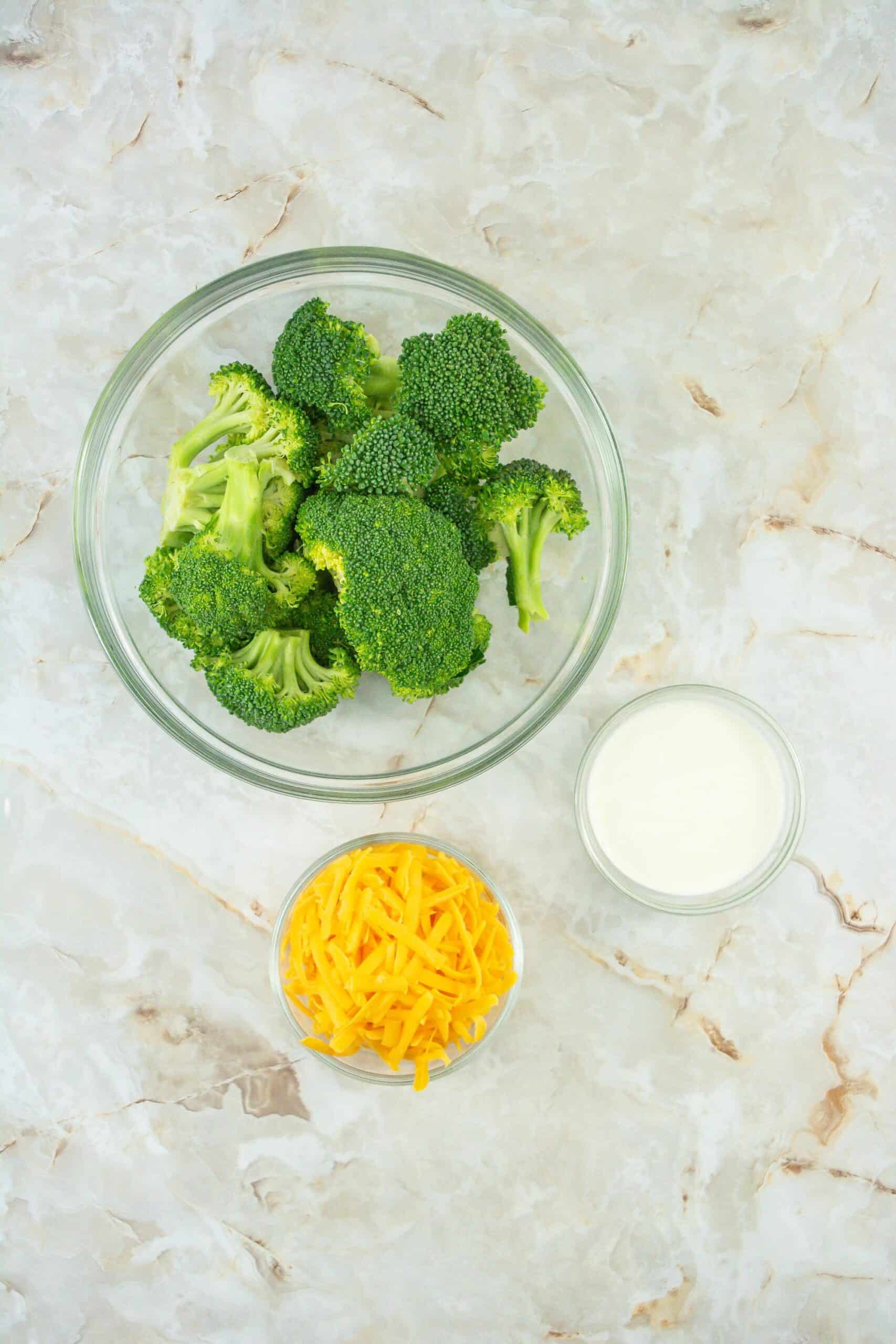 Ingredients to make 3 ingredient broccoli cheese casserole, broccoli, cheddar cheese and cream. 