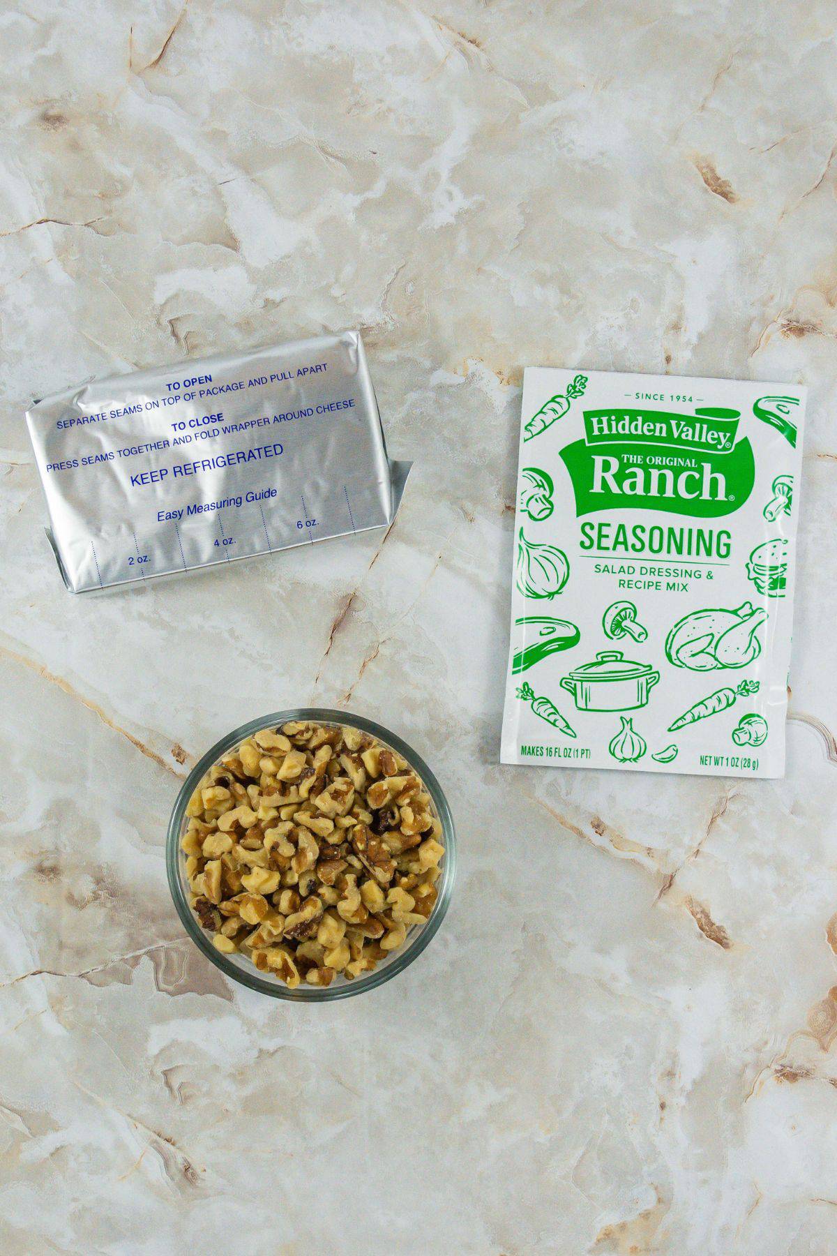 ingredients to make cheese ball: cream cheese, ranch dressing mix, and chopped walnuts
