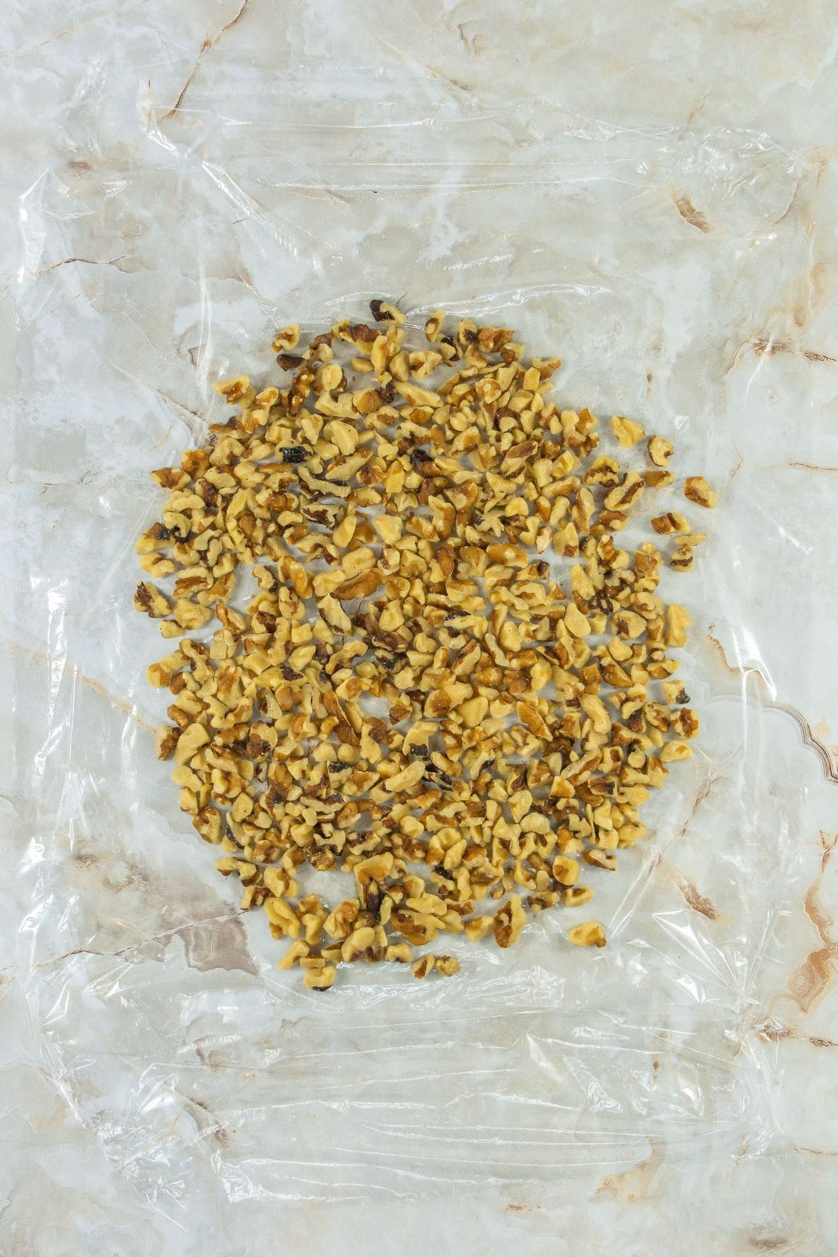a layer of chopped walnuts in the middle of a plastic wrap