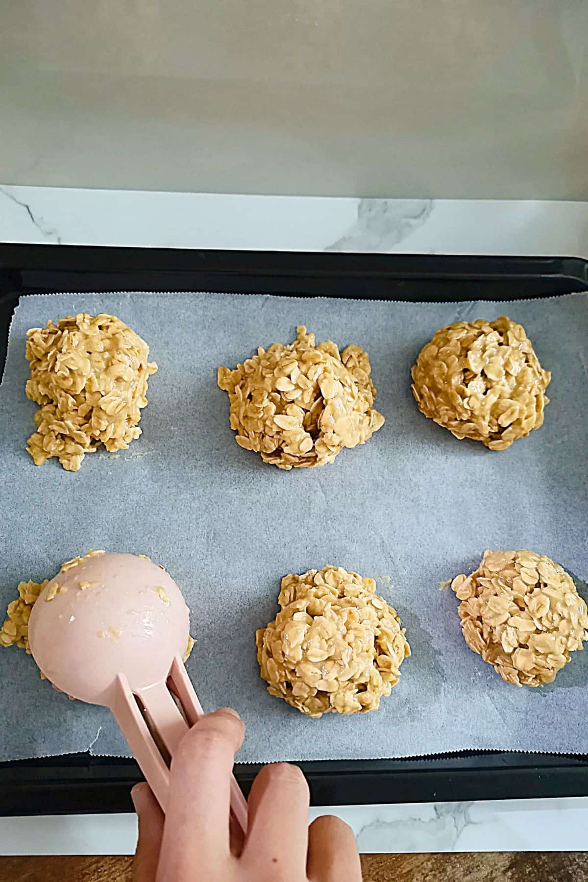 scooping dough onto a parchment-lined baking sheet