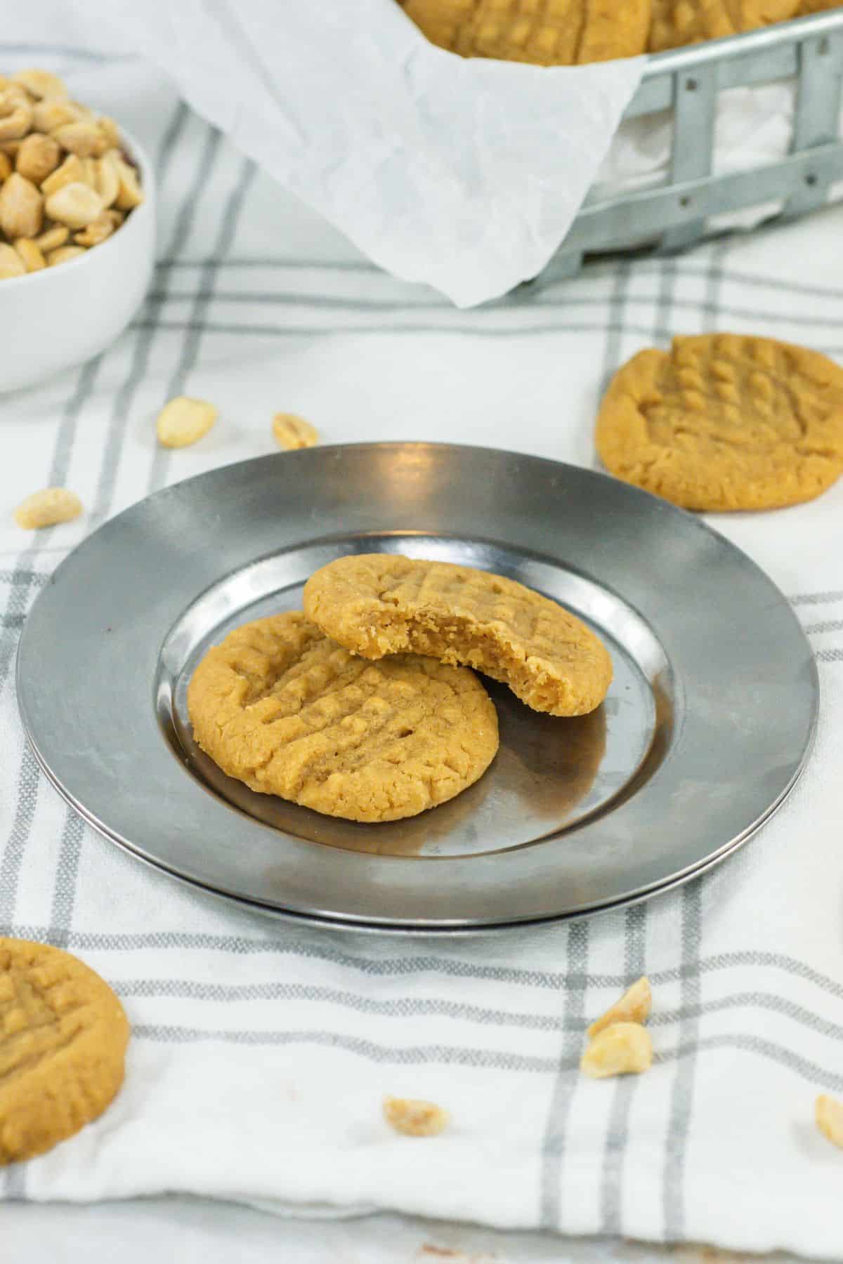 a plate of two cookies with a bite on one piece