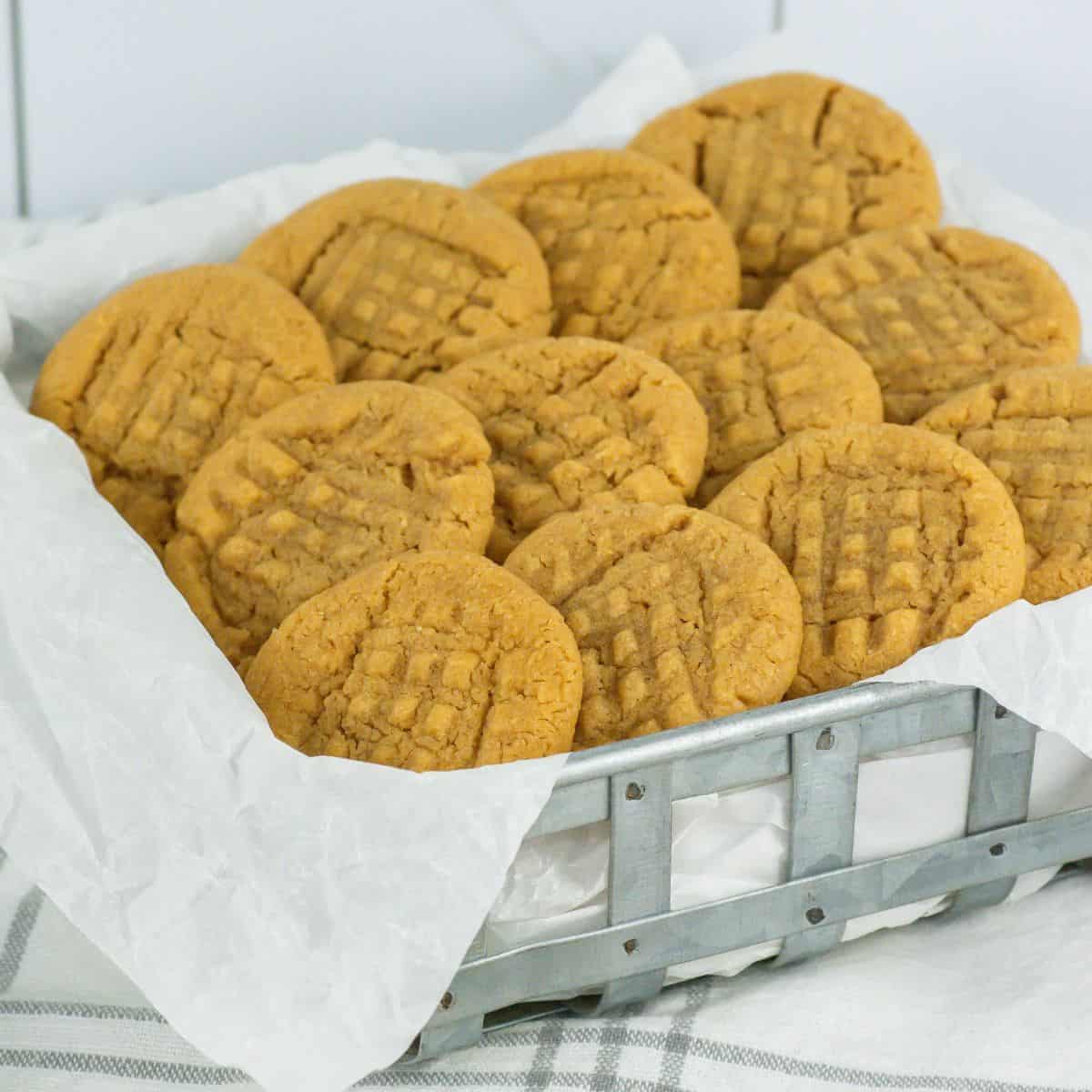 metal tray with a dozen 3 ingredient peanut butter cookies on parchment paper
