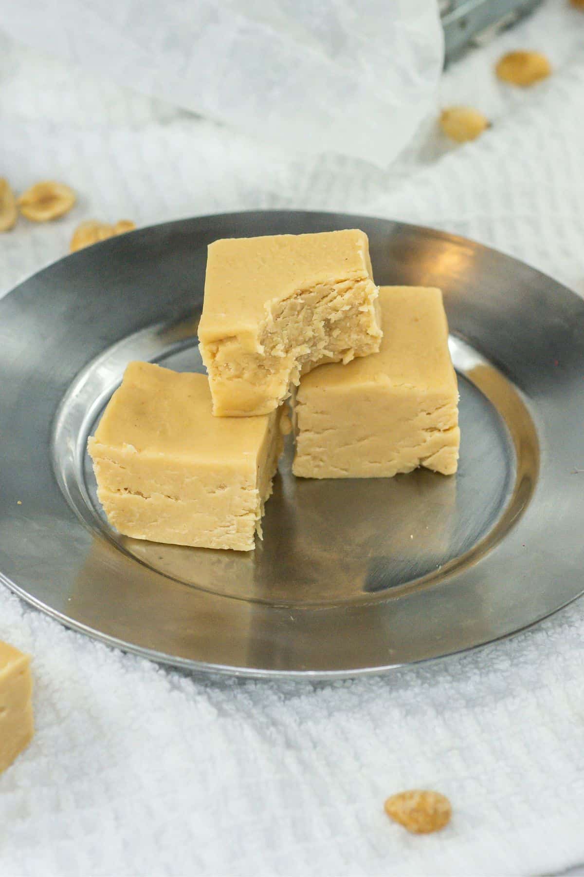 a close-up shot of three peanut butter fudge squares with a bite on one piece