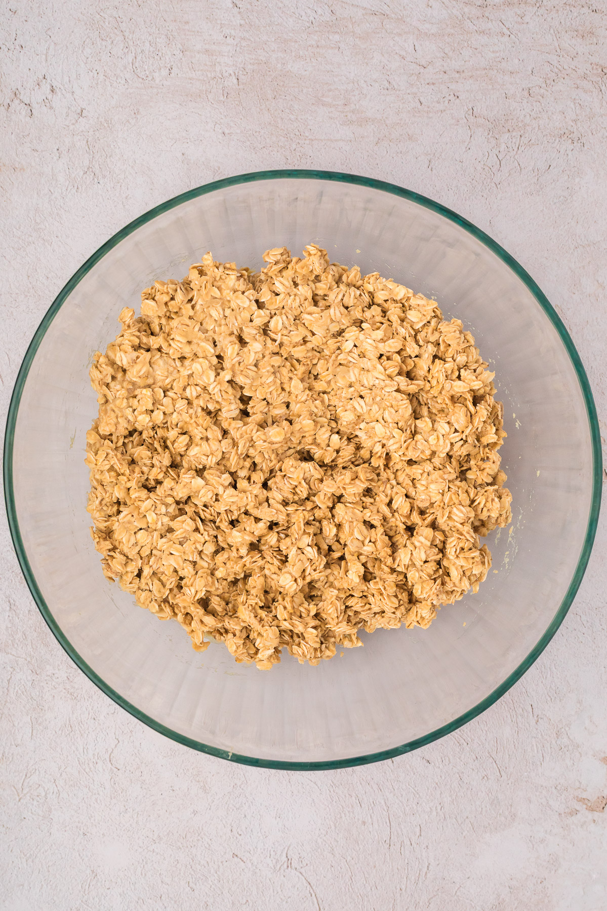 3 ingredient oatmeal cookie ingredients oats, honey and tahini all mixed in a bowl before baking