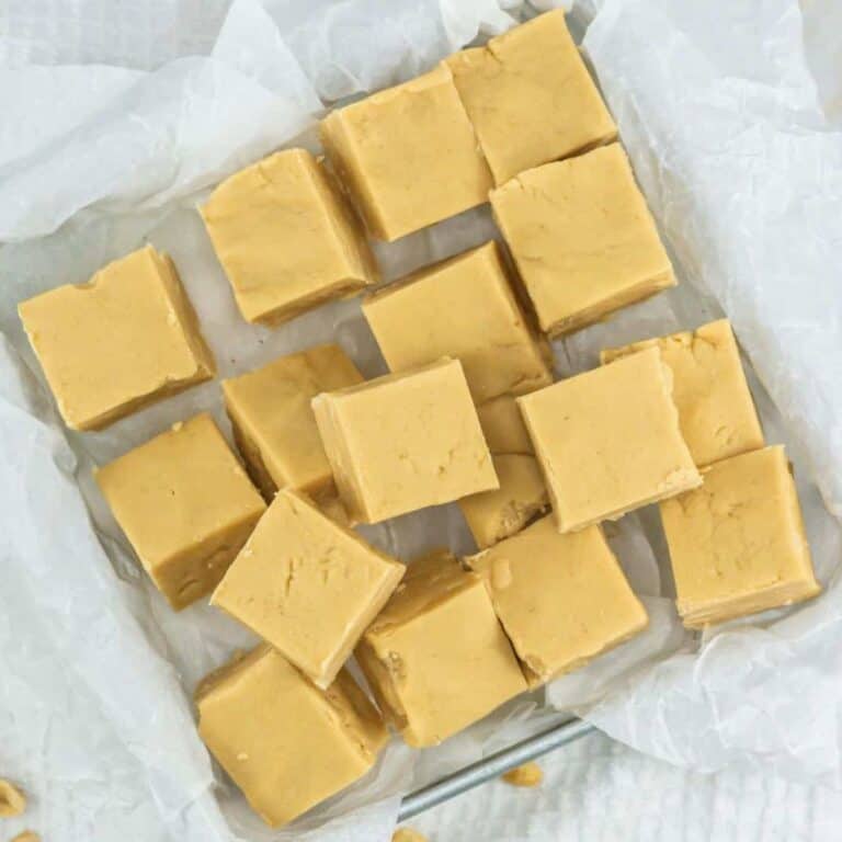 a tray of 3 ingredient peanut butter fudge with several squares in the 8x8 pan