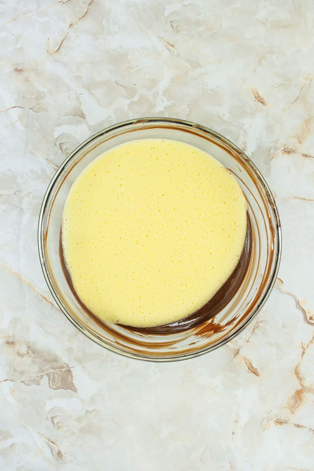 whisked eggs added to the melted chocolate mixture in a large bowl