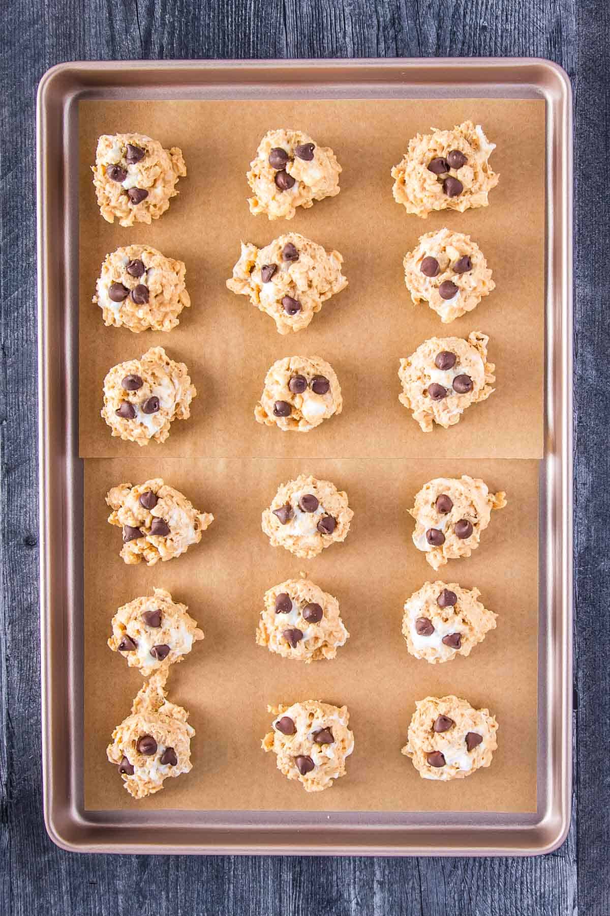 eighteen avalanche cookies arranged onto a parchment-lined tray
