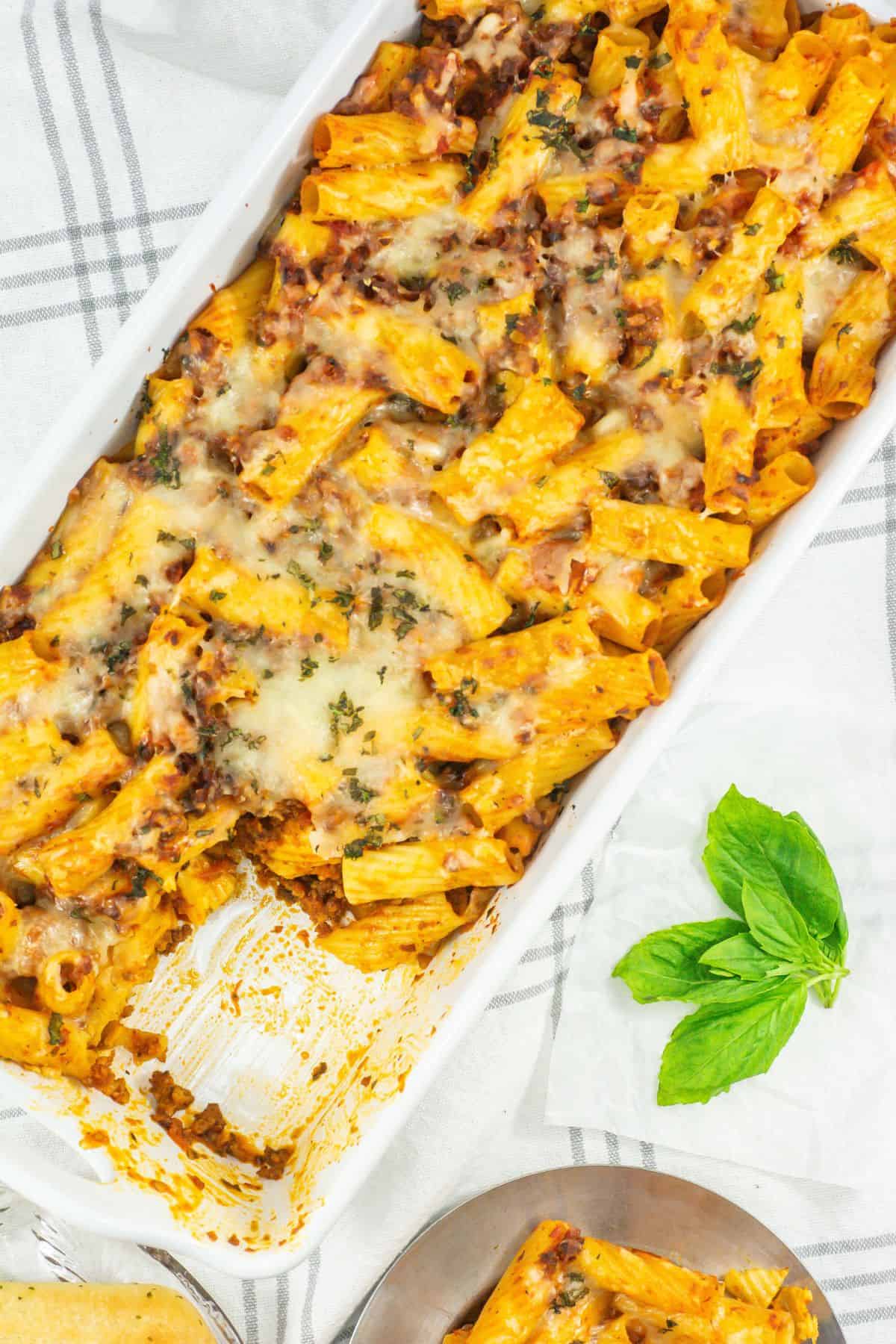 Baking dish of baked rigatoni: A casserole dish filled with golden-baked rigatoni topped with cheese and fresh herbs.