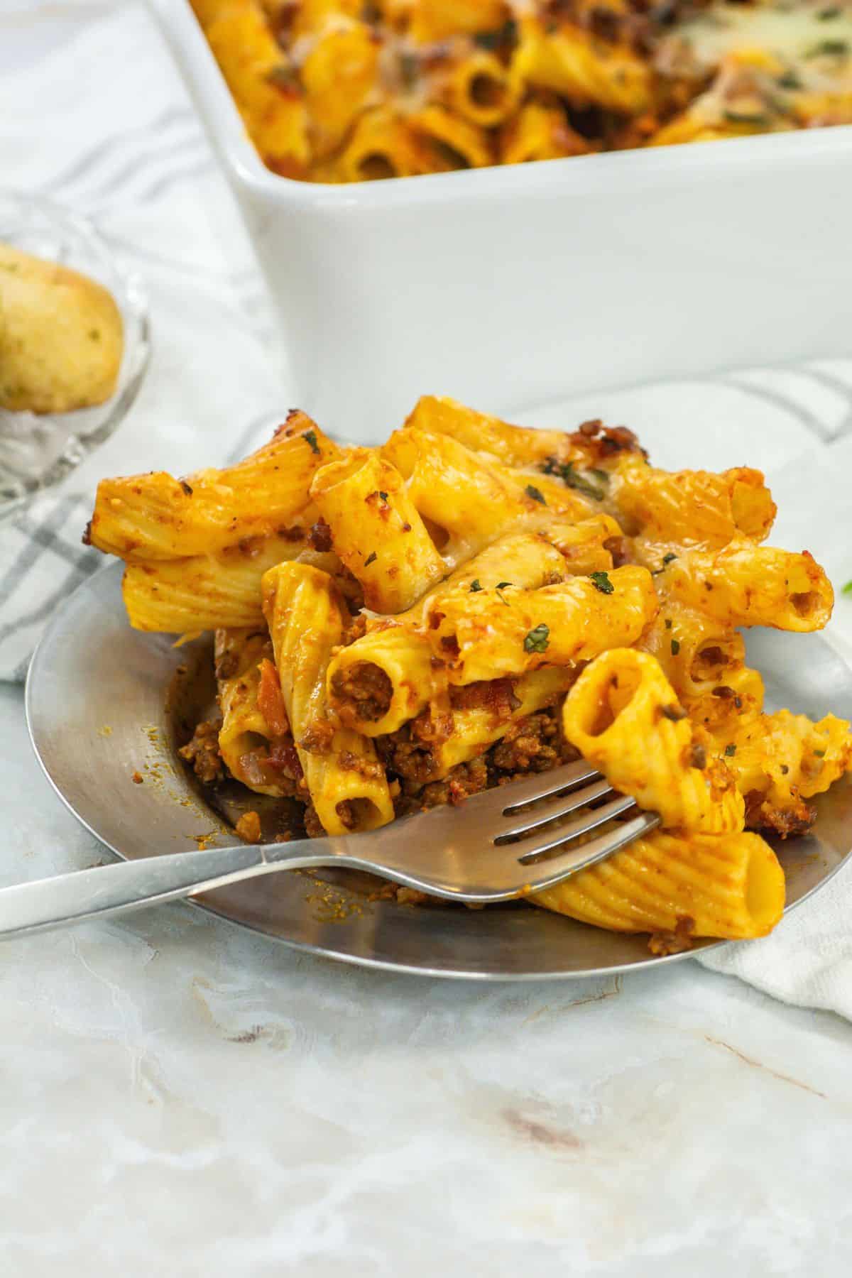 Another plated angle: A closer perspective of the cheesy, meaty rigatoni portion on a plate, highlighting the texture and vibrant colors.